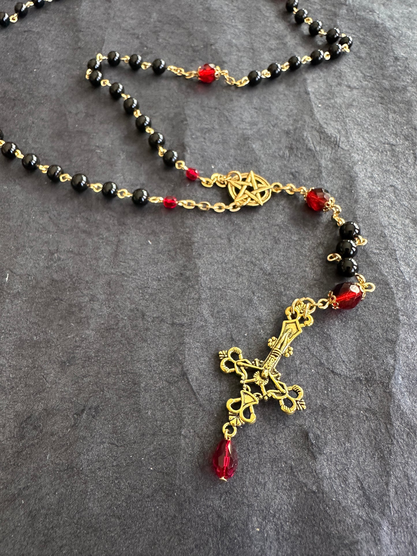 Black bead and gold rosary with red drop