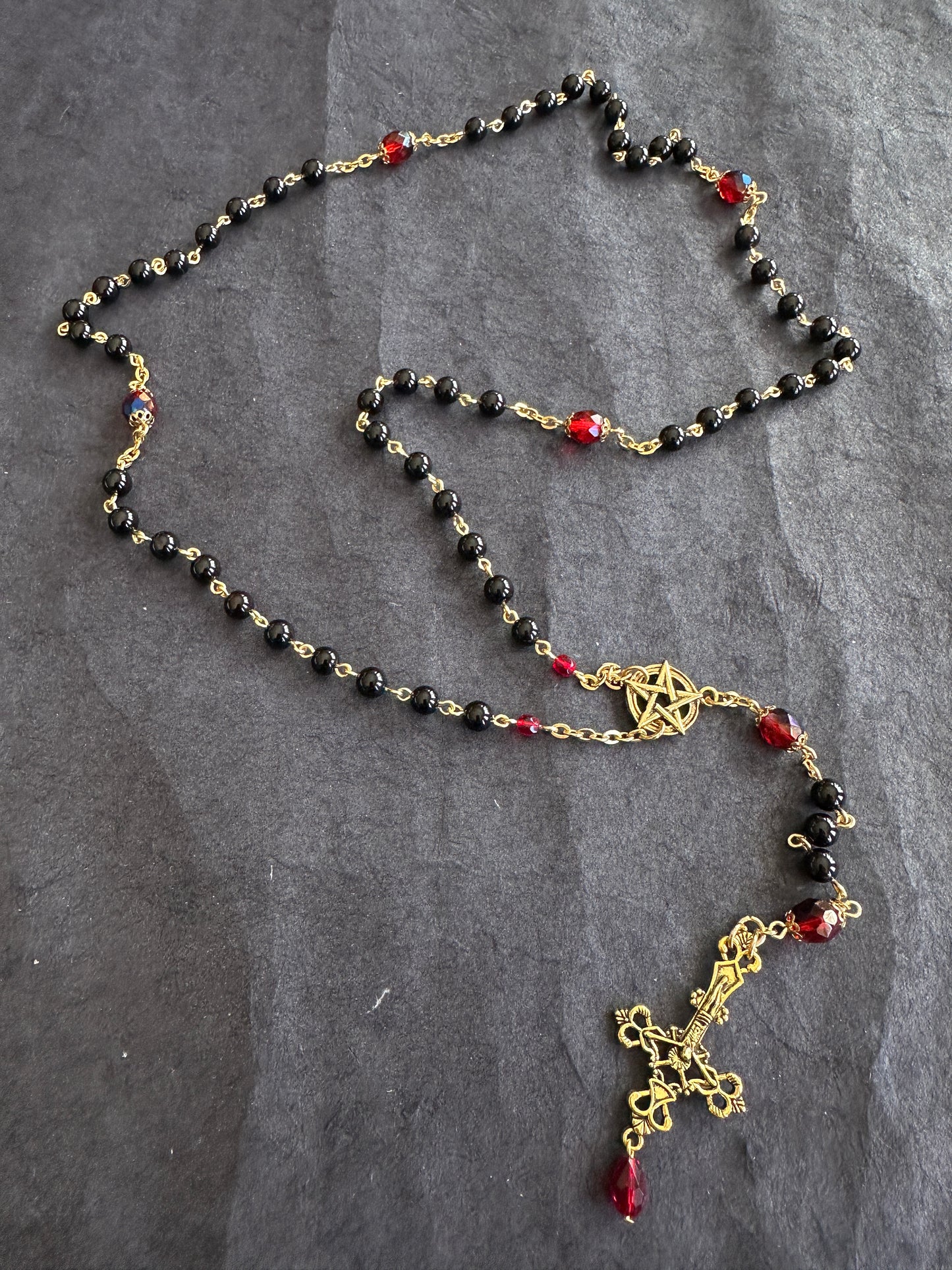 Black bead and gold rosary with red drop
