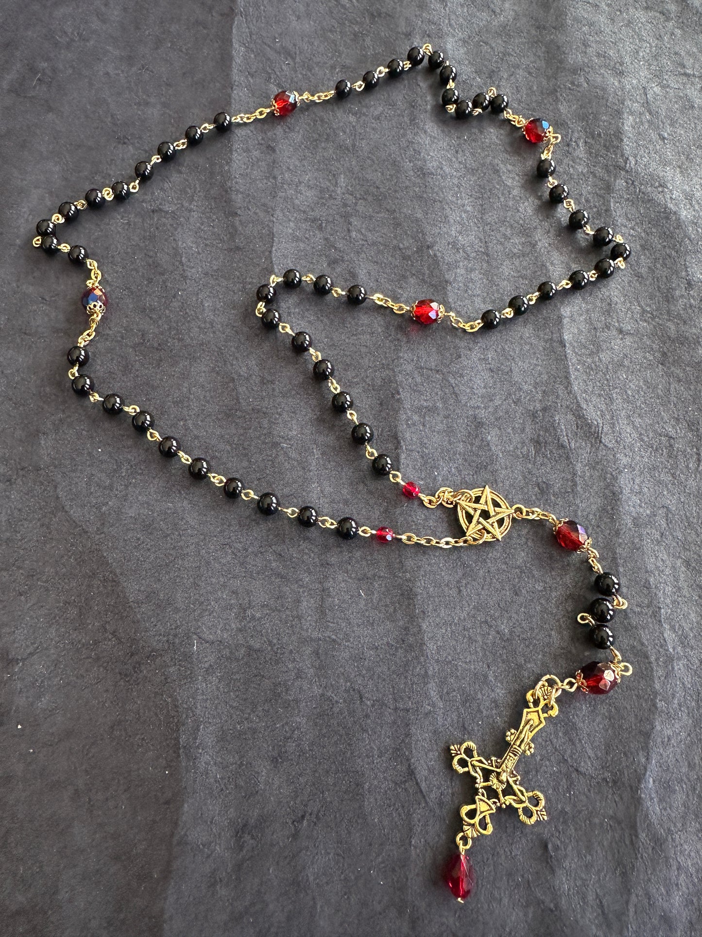 Black bead and gold rosary with red drop