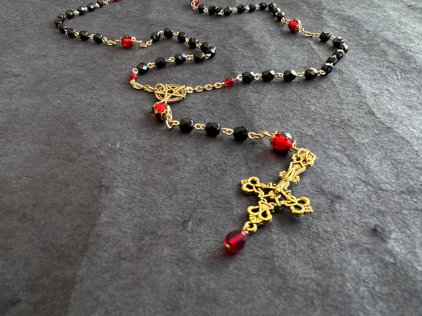 Black bead and gold rosary with red drop
